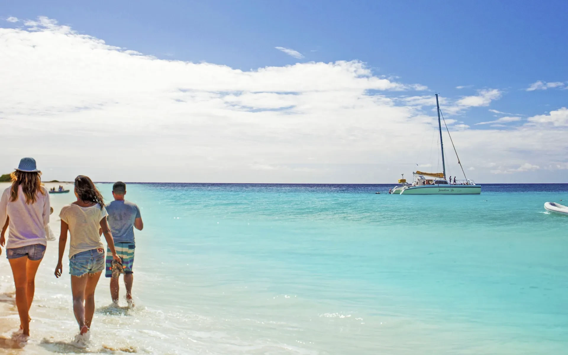 Friends walk on the beach in Klein Curacao in 2025