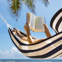 Woman reads a book in the a hammock in the Caribbean